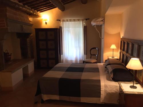 a bedroom with a large bed and a window at Locanda Petrella in Cortona