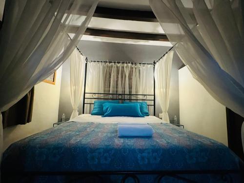 a bedroom with a large bed with blue pillows at Hotel Boutique Casa Miranda in Querétaro