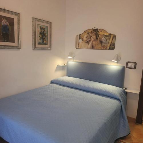 a bedroom with a blue bed and a painting on the wall at Alloggio per uso turistico ECM Giardino di Roma in Vitinia