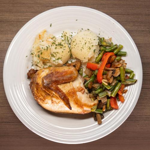 a plate of food with meat and vegetables on a table at Crowne Plaza Saint John Harbour View by IHG in Saint John