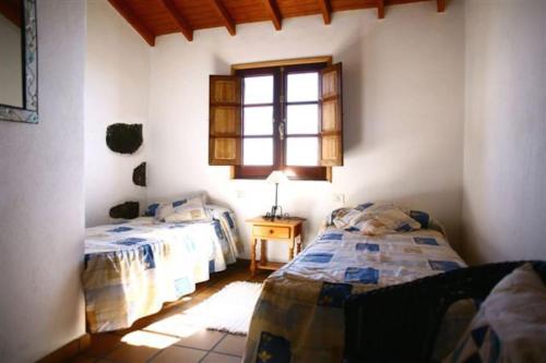 a bedroom with two beds and a window at VV Las Vistas de El Pinar in El Pinar del Hierro