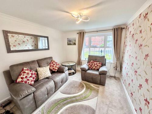 a living room with a couch and a chair at A luxury detached 4 bed home in Pontnewydd