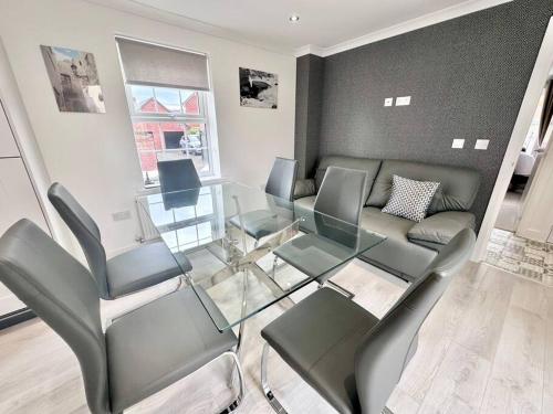 a living room with a glass table and chairs at A luxury detached 4 bed home in Pontnewydd