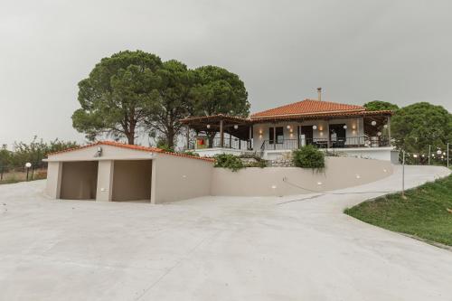 a house with a driveway in front of it at On the hill Residence in Makrikhórion