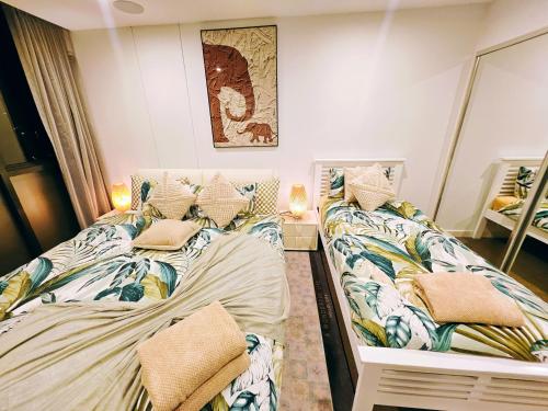two twin beds in a room with a mirror at Eden - Fast & Furious 伊甸园 - 速度与激情 in Adelaide
