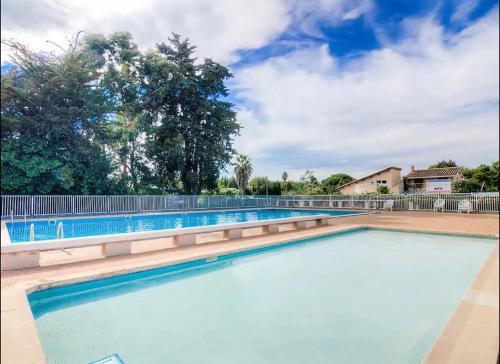 une piscine vide avec une clôture et des arbres dans l'établissement Appartement avec grande terrasse, à Saint-Cyprien