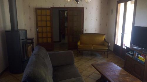 a living room with a couch and a television at Les Mimosas in Brens