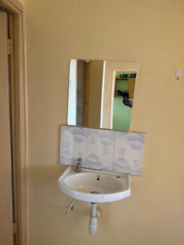 a white sink in a bathroom with a mirror at Enchanting Oasis in Embu