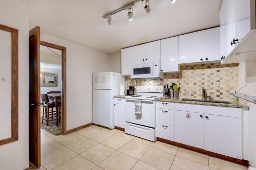 a kitchen with white cabinets and white appliances at Eagles Nest in Vail