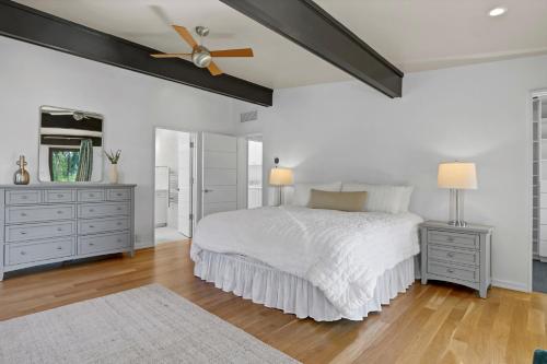 a bedroom with a white bed and a ceiling fan at Masons View by Sea Scape Properties in Wrightsville Beach