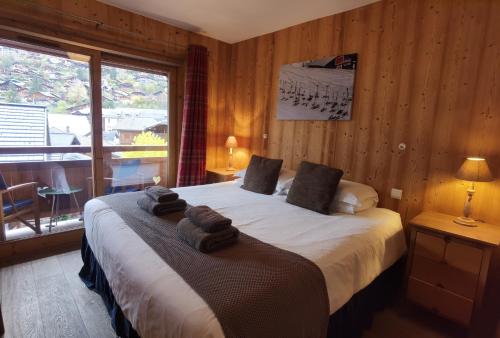 Un dormitorio con una cama grande con toallas. en Errigal Apartment, en Morzine