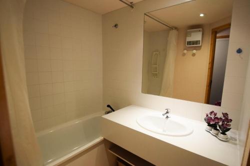 une salle de bain avec un lavabo, une baignoire et un miroir dans l'établissement Résidence Aime 2000 - Studio 3/4 pers. Partie Étoile - PLAGNE AIME 2000 MAE-5884, à La Plagne Tarentaise