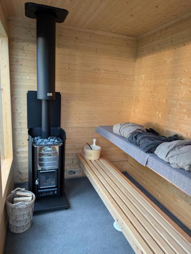 a log cabin with a wood stove in it at Borghildstua Feriehus Romslig feriehus med panoramautsikt mot havet og Lofotfjellene in Melbu