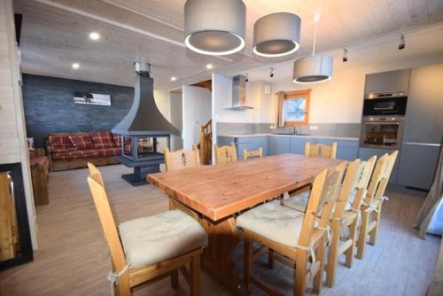 une cuisine et une salle à manger avec une table et des chaises en bois dans l'établissement Les Chalets Des Praz - Chalet LES PRAZ -10 pers - PLAGNE VILLAGES MAE-9674, à Aime La Plagne
