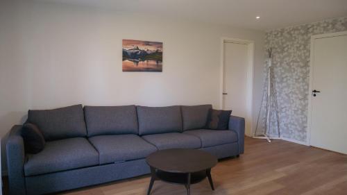 a living room with a blue couch and a table at Rådjursstigen 2A Vimmerby in Vimmerby