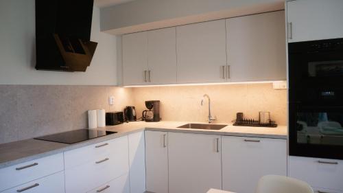 a kitchen with white cabinets and a sink at Rådjursstigen 2A Vimmerby in Vimmerby