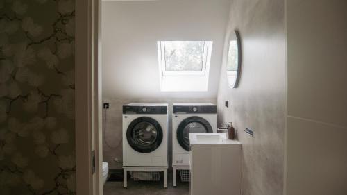 a laundry room with a washing machine and a sink at Rådjursstigen 2A Vimmerby in Vimmerby