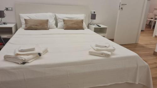 un letto bianco con sopra asciugamani di Gabriellihome a Pescara