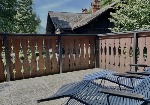 a wooden fence with two chairs on a patio at Design&Natur - hochwertige Ferienwohnung "Sundowner" in alter Villa in Grünau im Almtal