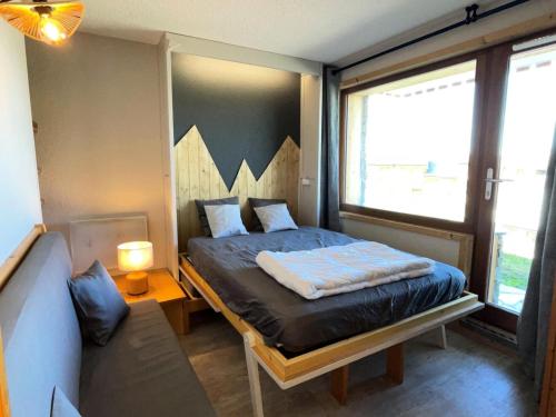 une petite chambre avec un lit et un canapé dans l'établissement Résidence Squaw Valley - Studio pour 4 Personnes 991, à Aime La Plagne