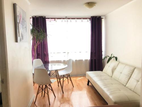 una sala de estar con un sofá y una mesa en Smart Apart, en Santiago