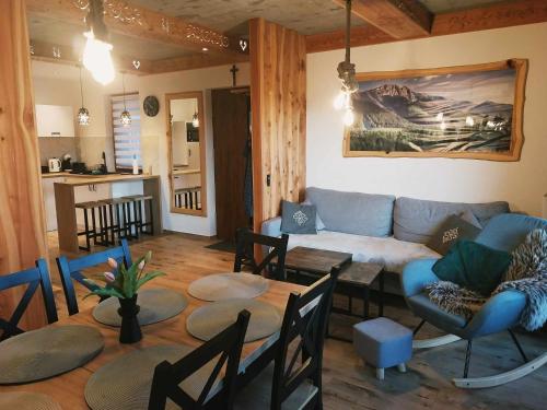 a living room with a couch and a table and chairs at Domki Na Brzyzku - Domek w górach z balią z jacuzzi in Zakopane