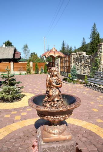 a statue of a girl in a fountain with an umbrella at Den House in Ludvikuvka