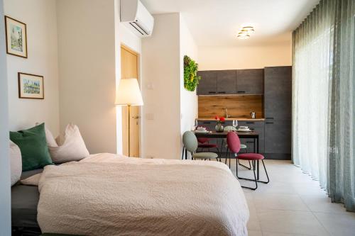 a bedroom with a bed and a table with chairs at Idyllische Wohnung mit Garten und Pool in Bardolino