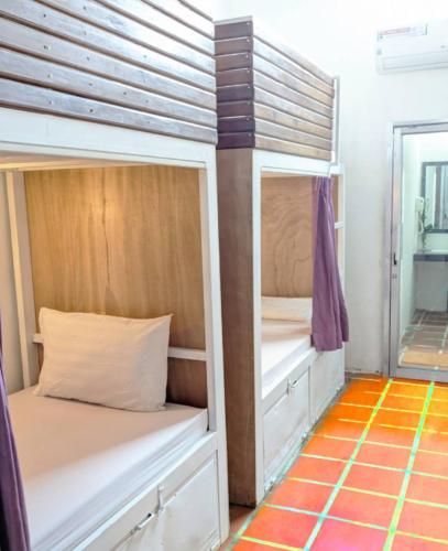 a room with two bunk beds and a mirror at The Siem Reap Chilled Backpacker in Siem Reap