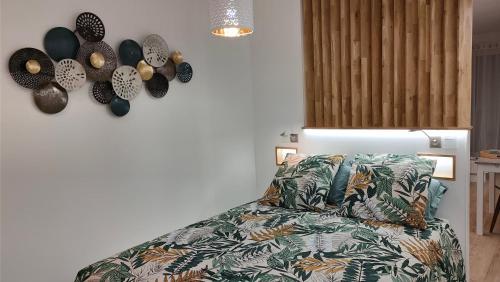 a room with a bed with a pillow and a clock on the wall at Appartement cosy en centre-ville de Royan à 200m plage in Royan