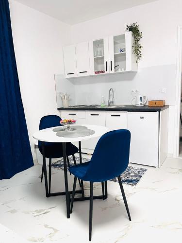 a kitchen with a table and blue chairs at EFESA Apartments in Visoko