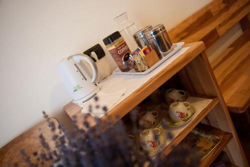 a small shelf with cups and tea pots on it at Agritur Renetta in Tassullo