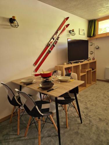 une table avec des chaises et une table en bois avec une lucarne dans l'établissement Le Cosy-Morzine, Multipass Provider !, à Morzine