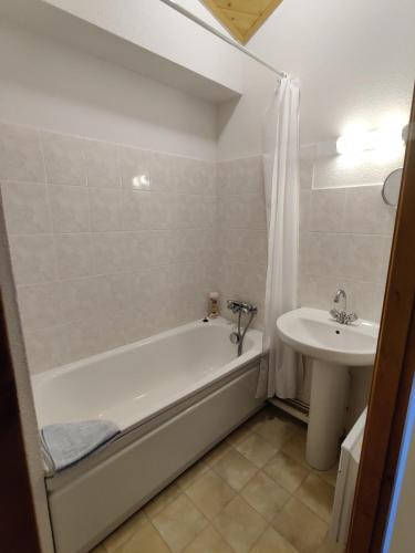 une salle de bain avec une baignoire et un lavabo dans l'établissement OursBlanc, à Thollon-les-Mémises