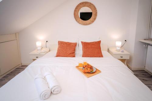 a white bed with a tray of food on it at Pharos Sunset - Stari Grad Center in Stari Grad