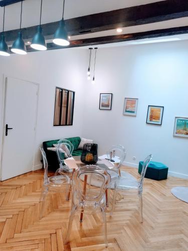 une pièce avec une table, des chaises et un canapé dans l'établissement Spacieux appartement proche de Paris Stade de France Métro, à Aubervilliers