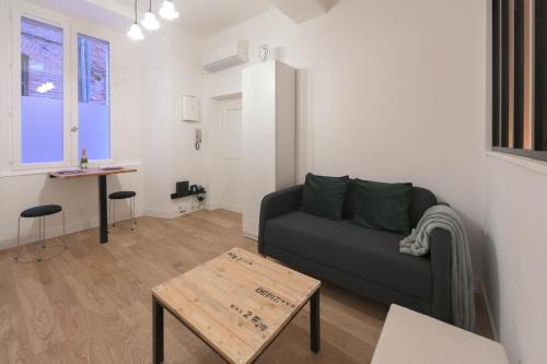 un salon avec un canapé et une table dans l'établissement Appartement T1 bis L'enfilade, à Albi