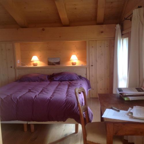 - une chambre avec un lit et deux lumières sur le mur dans l'établissement chalet classé 4 étoiles face aux Aravis plein sud 12 personnes, au Grand-Bornand