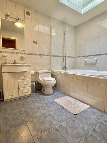 a bathroom with a toilet and a tub and a sink at DEPARTAMENTOS CLIMENT in Osorno