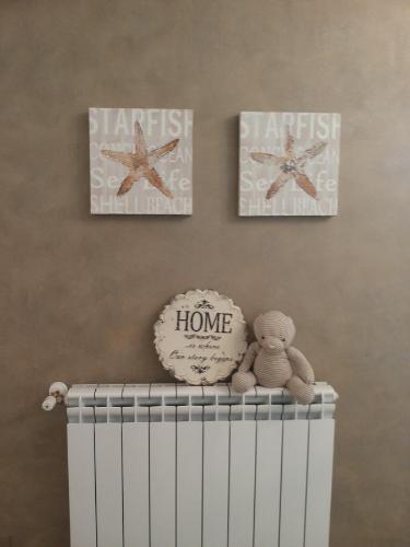 a crib with three pictures on the wall and a teddy bear at Mediterranea Sea House in Montesilvano