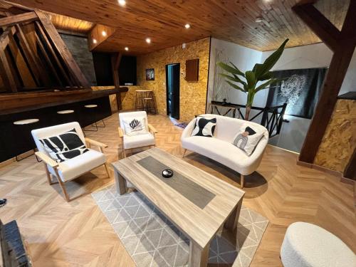 - un salon avec des chaises blanches et une table basse dans l'établissement La Renardière, à Neufchâteau