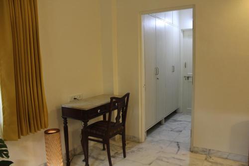a room with a desk and a chair and a hallway at Deluxe Suite in Champa Villa in Gandhinagar
