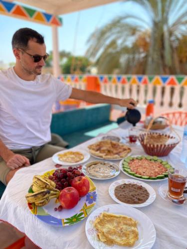 a man sitting at a table with plates of food at La Veranda 陽台 in Aswan
