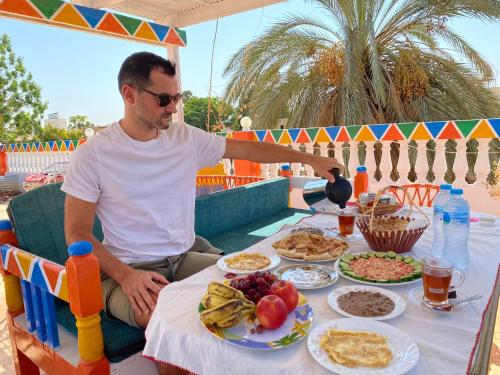 a man sitting at a table with food at La Veranda 陽台 in Aswan