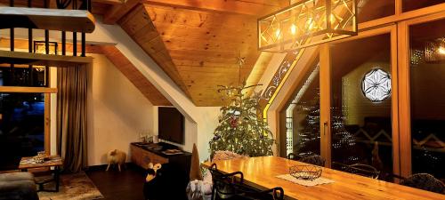 a living room with a christmas tree and a dining table at Luxury apartment with sauna and garden on the Czorsztyn lake in Kluszkowce