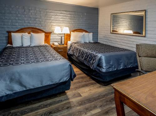 a hotel room with two beds and a table at Hitching Post Studios Inn in Santa Cruz