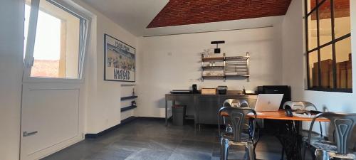 Habitación con mesa con sillas y ordenador portátil. en Casa del Mercante in centro ad Asti no ztl, en Asti