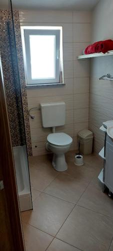 a bathroom with a toilet and a window at Ana Marija in Solin