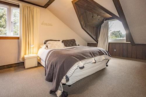 a bedroom with a large bed in a attic at The Shed in Rangataua