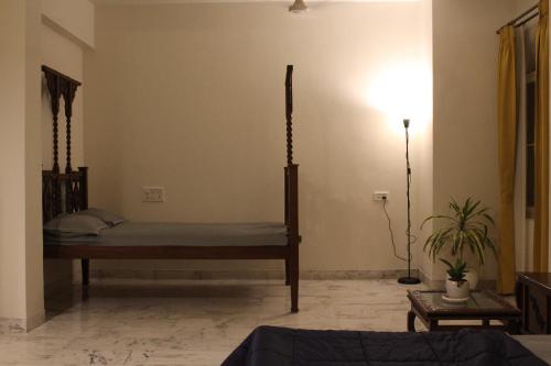 a bedroom with a bed and a lamp in a room at Super Deluxe Suite in Champa Villa in Gandhinagar